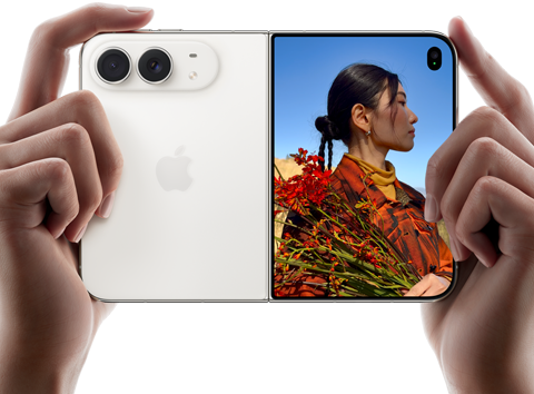 iPhone&nbsp;Duo, Star White colour, held by two hands in horizontal orientation, unfolded, left panel shows 48MP Dual Fusion rear cameras, right panel shows person getting their picture taken on outer display, the subject of the photo is able to see their face as their picture is getting taken using Duo Preview